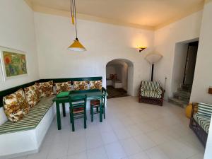 a living room with a couch and a table at Garden View Traditional House in Tripiti