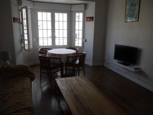 a living room with a table and chairs and a television at Appartement Chaussee du Sillon in Saint Malo