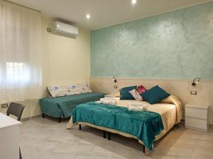 a bedroom with two beds and a green wall at Le Nonne HOUSE - Assemini - free parking P in Assemini