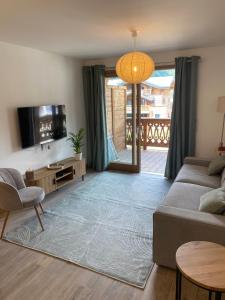 a living room with a couch and a tv at Apartment Okami in Morzine