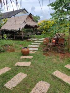 a path leading to a hut with chairs and grass at Economy double room with fan only and external bathroom facilities in Ban Chak Khamin