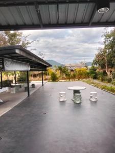a pavilion with a white table and chairs at Economy double room with fan only and external bathroom facilities in Ban Chak Khamin