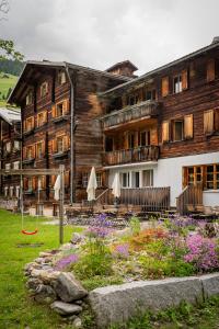 Safien PlatzにあるGasthaus Rathausの大きな木造の建物(正面に庭園あり)