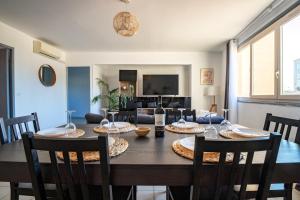 a dining room with a table with chairs and a couch at Centre - Clim - Parking - Esplanade de l'Europe in Montpellier