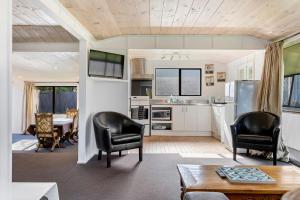 a kitchen with black chairs and a table in a room at Good times at the Lake in Mangakino