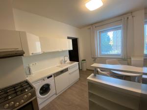 a kitchen with a washer and a sink and a stove at Apartmán Konštantínova in Prešov