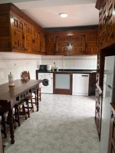 a kitchen with wooden cabinets and a table in it at La Casa del Ebanista - Santillana in Santillana del Mar