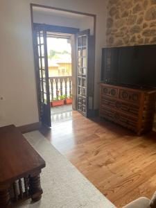 a living room with a television and a wooden floor at La Casa del Ebanista - Santillana in Santillana del Mar +11 photos