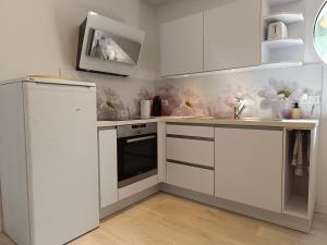 a kitchen with white cabinets and a white refrigerator at Appartement avec vue exceptionnelle in Blanzat +7 photos