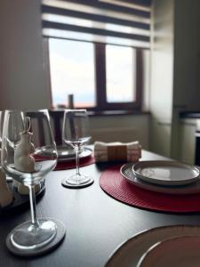 a table with two wine glasses and a red napkin at RelaxMontan Apartment Sanpetru in Sînpetru +4 photos