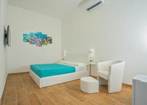 Sea Dream Camere في أغروبولي: غرفة نوم بيضاء بسرير وكرسي