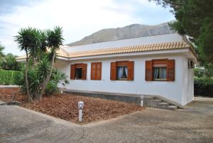 una casa con una palmera delante de ella en Villa Messi, en Castelluzzo