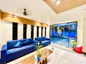 a living room with a blue couch and a table at Near Sea Beach HOTEL RB-INN ! Puri,Near Jagannath Temple- Fully Air conditioned Rooms ,Wifi,- Lift and Restaurant, Parking Facilities - A Top Rated Hotel IN PURI in Puri