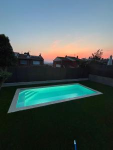 a swimming pool in a yard with a sunset at Villa Marta - Girona in Girona