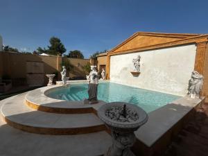 a swimming pool with a fountain in a yard at LA FUENTE ROMANA in Campo-Nubes