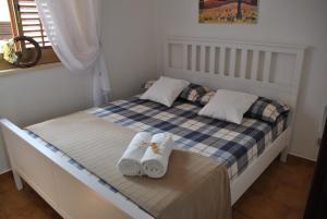 1 dormitorio con 1 cama con toallas en Villa Messi, en Castelluzzo