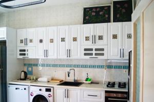 a kitchen with white cabinets and a sink at Hibe Dede Cappadocia in Ürgüp