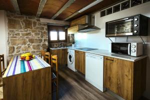 a kitchen with a table with a bowl of fruit on it at L'alberg la rectoria de la Torra in La Baronia de Rialb