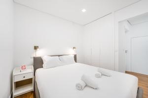 Un dormitorio blanco con dos camas y un espejo. en GuestReady - Restful Getaway in Matosinhos, en Matosinhos
