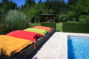 two beds on a wall next to a swimming pool at Les Carmes and spa in Le Thor