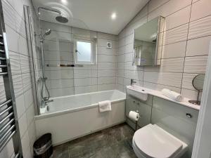 une salle de bain avec une baignoire, des toilettes et un lavabo dans l'établissement 15 Golden Bay Holiday Village - Coastal Retreat with Breathtaking Views, à Westward Ho 15 autres photos