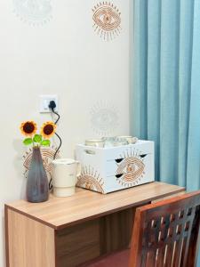 una mesa con un jarrón de flores y una radio en Bumble bee Jaipur, en Jaipur