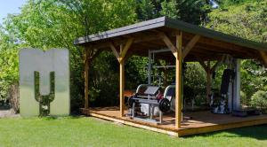 a gazebo with two chairs in the grass at Les Carmes and spa in Le Thor