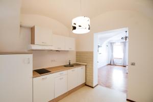 a kitchen with white cabinets and a light fixture at Guesthouse Stari Mayr in Kranj +35 photos