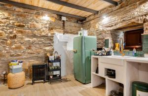 a kitchen with a green refrigerator in a stone wall at VUT La casita del Pajar in Vega de Espinareda +10 photos