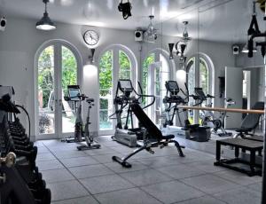 a gym with treadmills and ellipticals and a clock at White Brown Apartment in Bangi