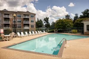 a large swimming pool with chairs and a building at White Brown Apartment in Bangi