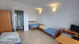 a small room with two beds and a television at Pod Złotym Żaglem in Karwia +18 photos