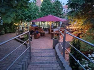 a patio with a table and an umbrella at Hotel von Euch in Meppen