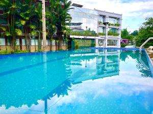 a pool of blue water in front of a building at Hotel Kingland in Ruwanwella