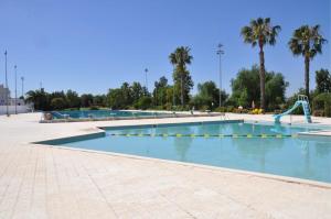 a large swimming pool with a slide in a park at Casa das Viagens in Ferreira do Alentejo