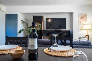 a bottle of wine on a table in a living room at Centre - Clim - Parking - Esplanade de l'Europe in Montpellier +11 photos