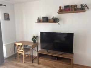 a living room with a television and a table with a chair at Brasov 35 Classic in Braşov