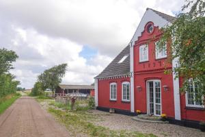 an old red building on the side of a dirt road at Blåbjerg Barn in Tønder