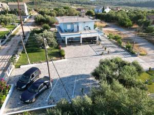 two cars parked in a parking lot in front of a house at Pame Apartments Only Adults in Valanidorachi