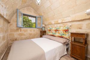 a bedroom with a bed and a window at Casa Varvodda in San Vito dei Normanni