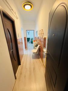 a hallway with a door and a chair in a room at Hășmaș Peak Escape in Bălan +12 photos