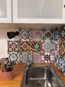 une cuisine avec un évier et du carrelage au mur dans l'établissement Enne29, à Reggio de Calabre