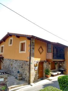 Casa amarilla con porche y balcón en Casa Lindelagua, en Pámanes
