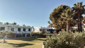 a resort with palm trees and a building at Villa Rizia in Kolimbia