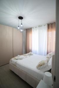 a bedroom with a white bed and a chandelier at Casa Sambò in Chioggia
