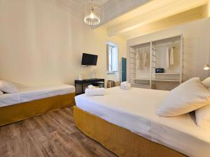 a bedroom with two beds and a desk with a mirror at Dolce Dormire in Palermo