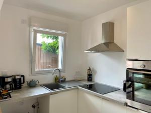 una cocina con fregadero y ventana en Les Acacias, en Notre-Dame-de-Riez