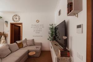 リミニにあるAmazHome - Il Rifugio degli Artistiのソファと壁掛け時計のあるリビングルーム