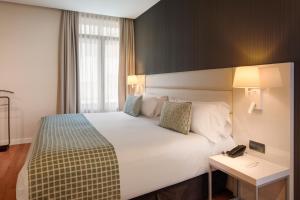 a hotel room with a large bed and a table at Catalonia Plaza Mayor Salamanca in Salamanca