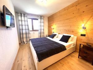 a bedroom with a large bed with a wooden wall at Esprit chalet-Le Snoroc C36 in Aime La Plagne +19 photos